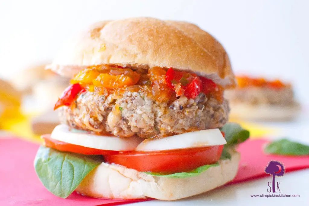 Close up of giant black eyed pea burger dressed with sweet pepper chutney lettuce, tomato, and onion