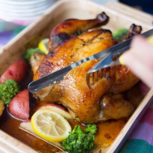 Hands carving sweet tea brined chicken