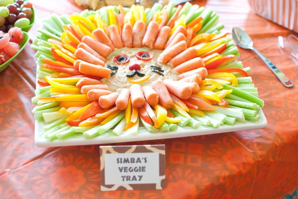 carrots, yellow peppers, and celery surrounding hummus made to look like a lion