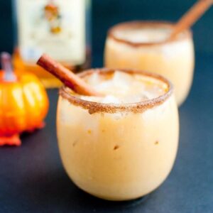 pumpkin horchata in a cinnamon sugar rimmed glass garnished with a cinnamon stick