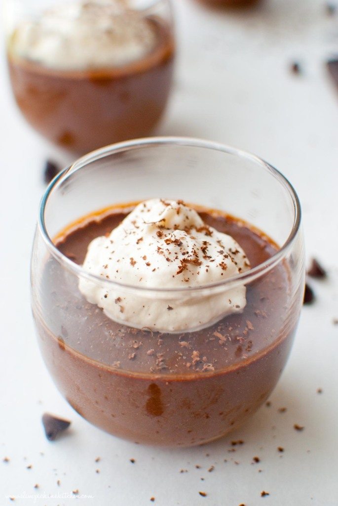 pots de creme close up in glass cup w/ whipped cream and chocolate sprinkles