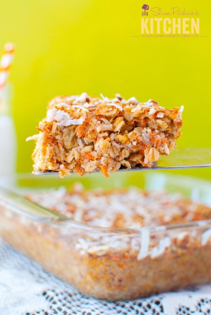 Large slice of healthy Carrot Cake Baked Oatmeal with pineapple on a spatula topped with coconut