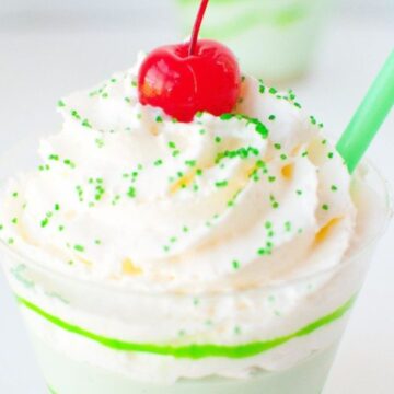 Close up of no bake shamrock shake no bake cheesecake with whipped cream and cherry on top