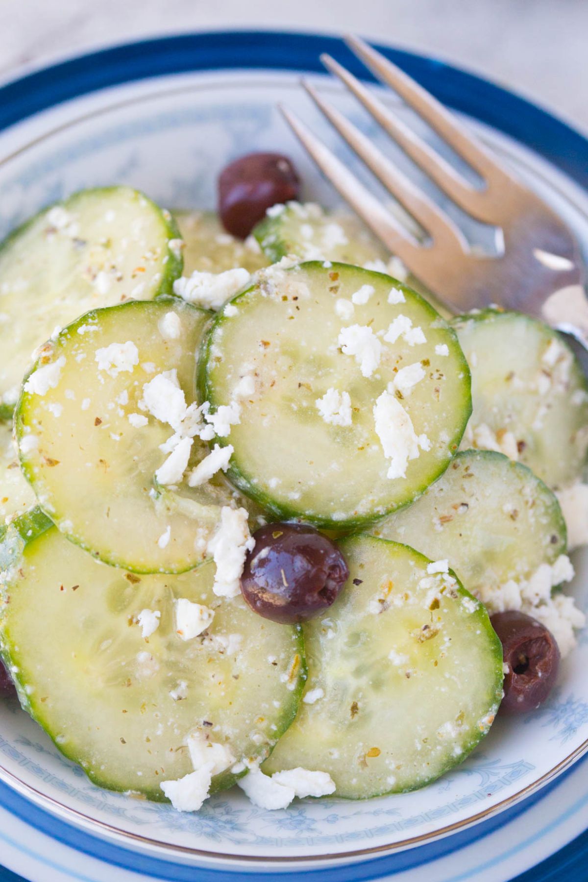 Close up of Cucumber Salad cut into rounds with crumbled feta and black olives 