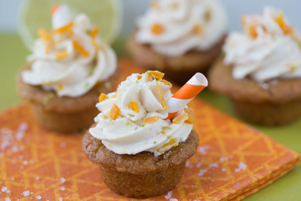 mini mango margarita cupcakes with a tiny orange and white striped straw