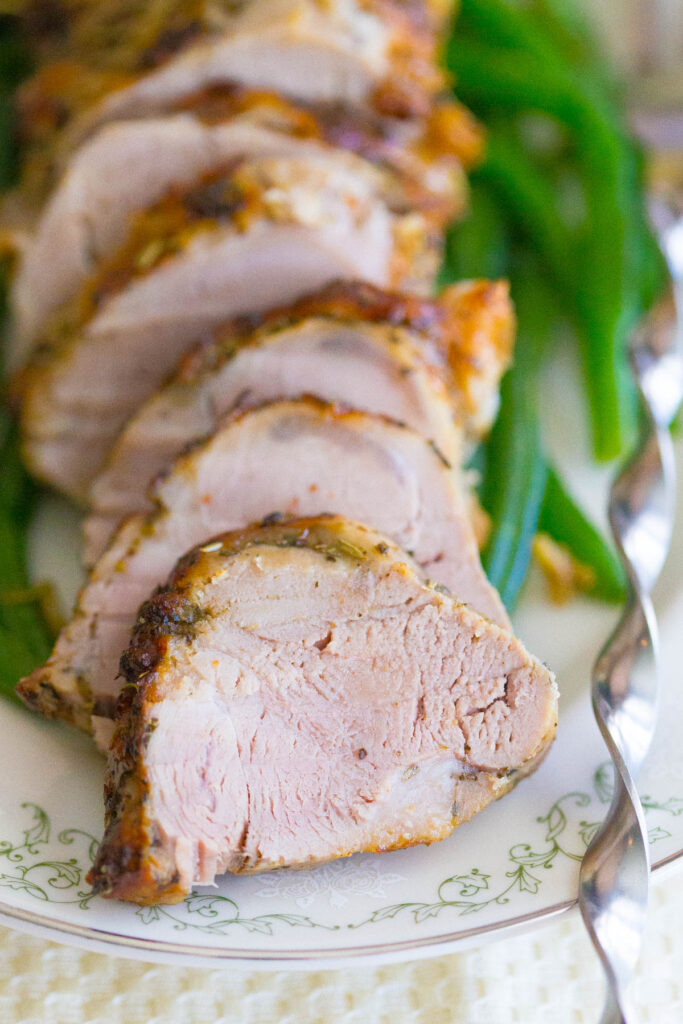 Slices of Easy Roasted Pork Tenderloin on a Plate with Green Beans