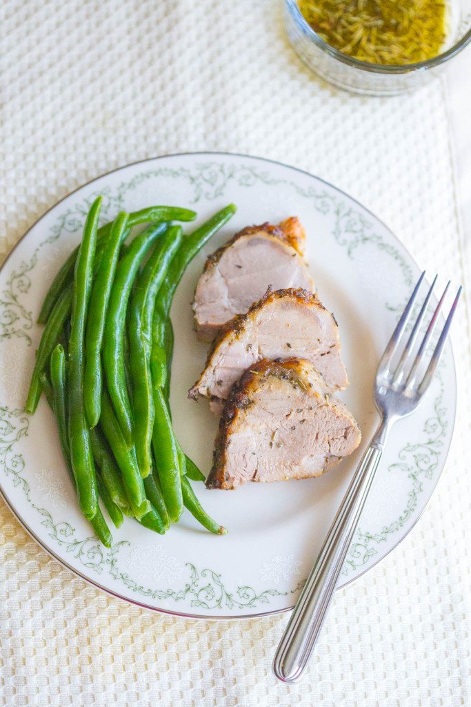 Overhead shot of Slices of Easy Roasted Pork Tenderloin on a Plate with Green Beans