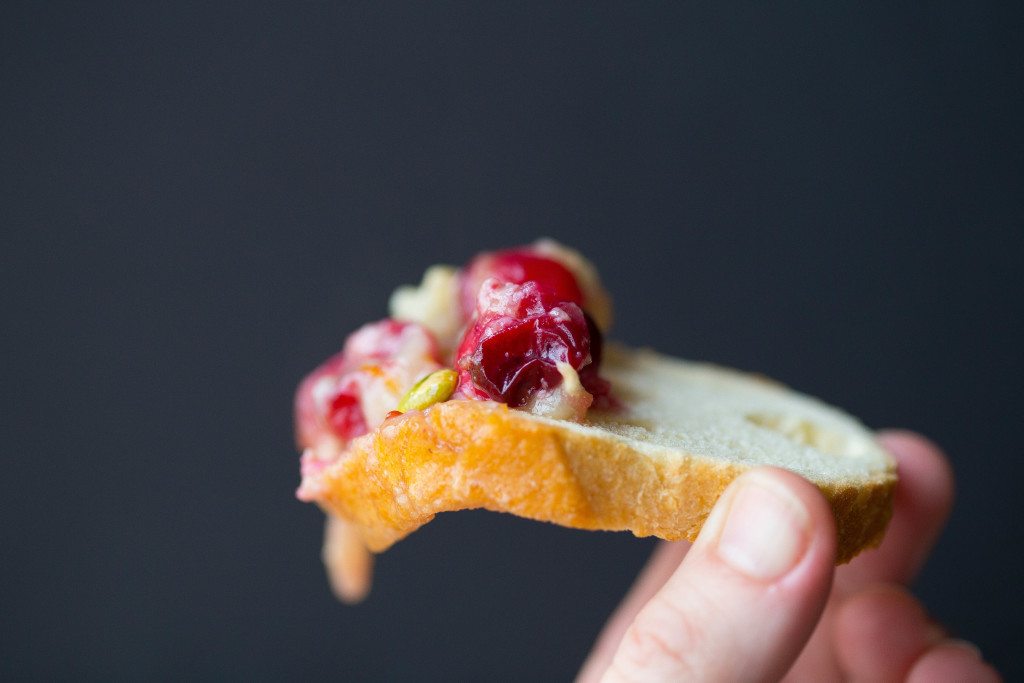 close up of dripping brie dip off toasted baquette