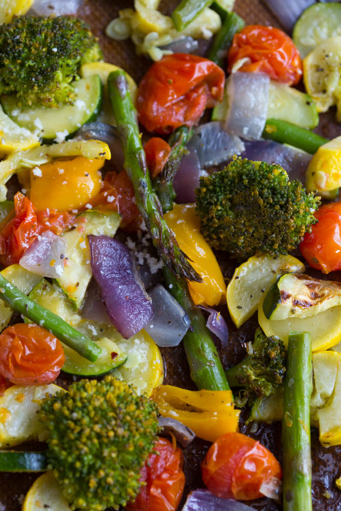 Healthy roasted vegetables like asparagus, broccoli, yellow peppers, red onion, zucchini, and squash