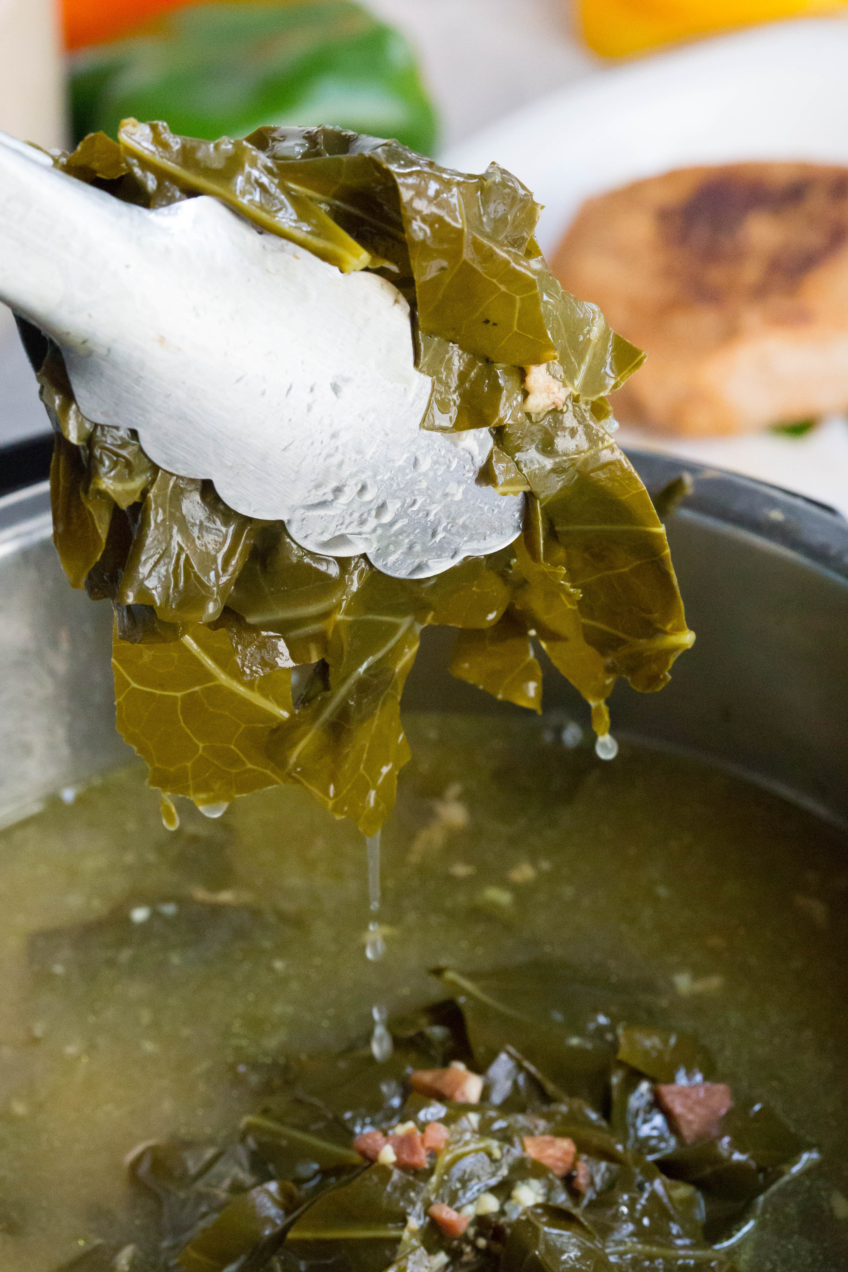 Instant Pot Collard Greens being grabbed with a pair of tongs