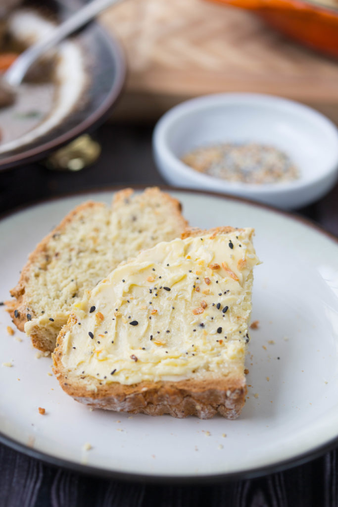 Slices of Everything Soda Bread on a Plate Sprinkled with More Everything Seasoning