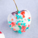 Close up of white chocolate covered cherry 4th of July Cherry Bombs with red and blue pop rocks