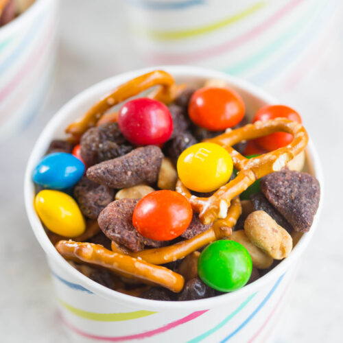 Close up of Peanut Butter and Jelly Trail Mix in small white cardboard bowl with colored stripes