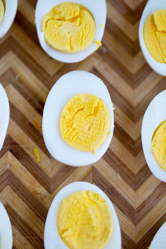 Perfect Instant Pot Hard Boiled Eggs in a row on cutting board