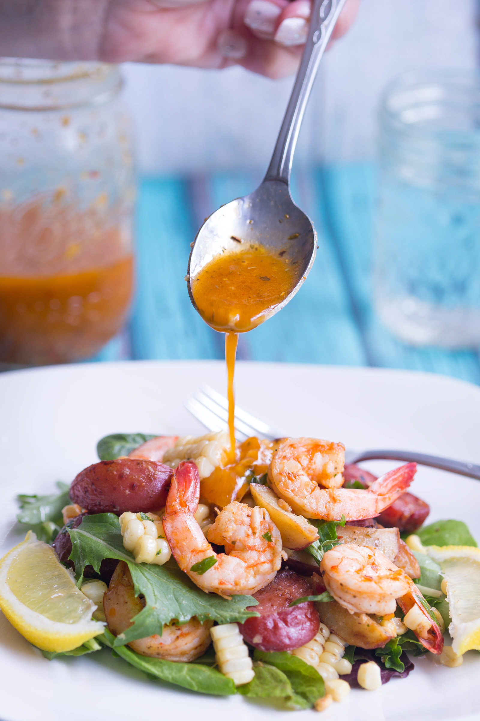 Lowcountry Boil Salad being drizzled with Old Bay Vinaigrette
