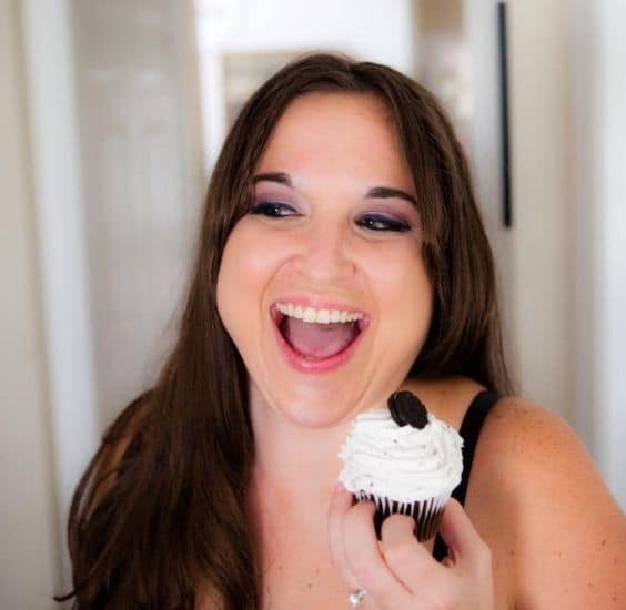 Headshot of Amber Forbes holding a cupcake and smiling