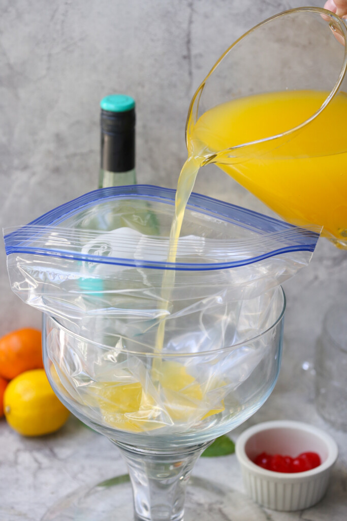easy slushy pineapple party punch pouring from pitcher into a plastic bag
