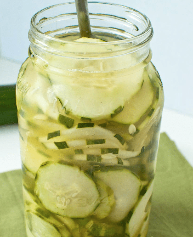 cucumbers and vinegar in a mason jar with a fork sticking out