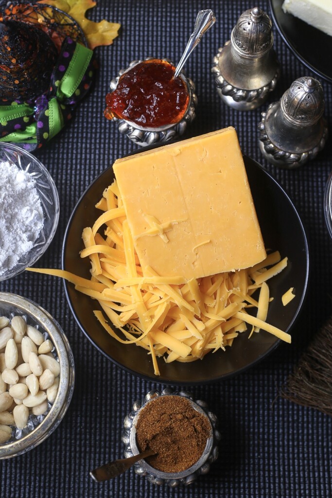 southern cheese straws ingredients in a black bowl surrounded by Halloween decor