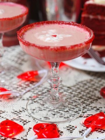 Red Velvet Chocolate Martinis in vintage martini glasses placed over lace table cloth rimmed with red sugar