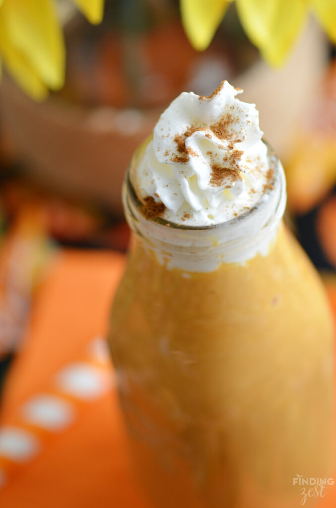 Close up of easy pumpkin smoothie recipe with whipped cream and a red swirled straw