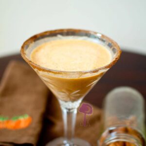 pumpkin spice latte martini in a martini glass rimmed with cinnamon sugar