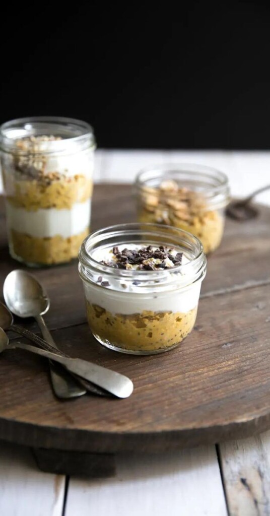 easy pumpkin pie overnight oats in glass jars on a lazy susan on a white table