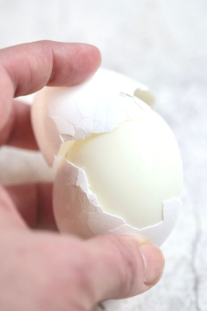 An easy peel egg: the white egg shell easily peeling away from the hard boiled egg