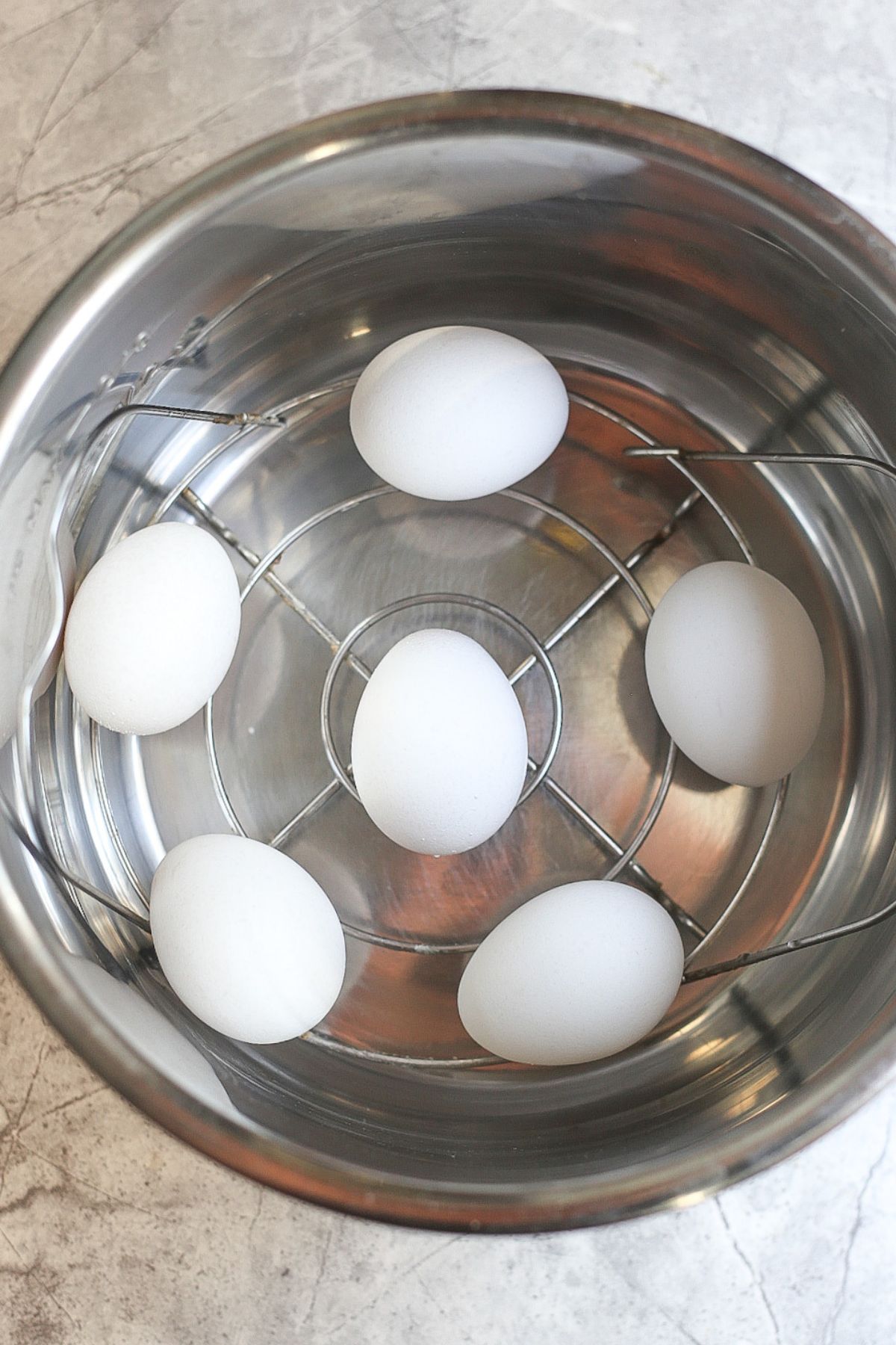 Overhead shot of 6 eggs in an Instant Pot on the provided trivet insert rack