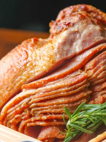 Close up of whole spiral ham (honey glazed ham) garnished with rosemary